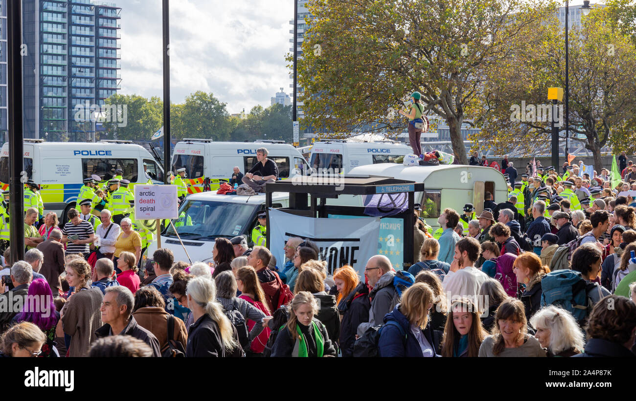 Millbank, London, Großbritannien, 15. Oktober 2019; eine Masse von Aussterben Rebellion Aktivisten mit einem schweren Polizei Prescence hinter Stockfoto