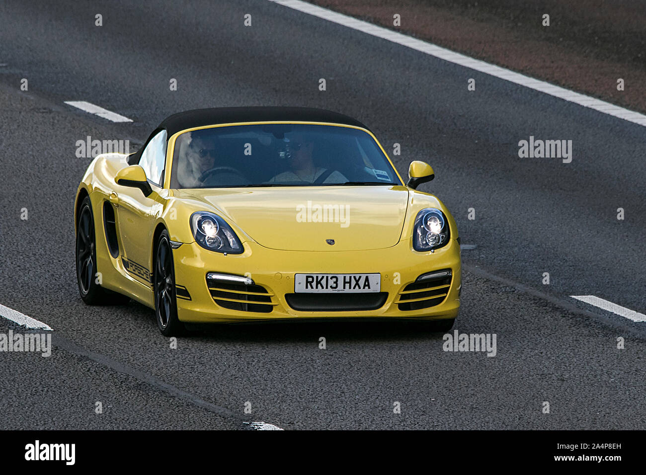 2013 gelbe Porsche Boxster 24 V S-A; Fahrt auf der Autobahn M6 in der Nähe von Preston in Lancashire, Großbritannien Stockfoto