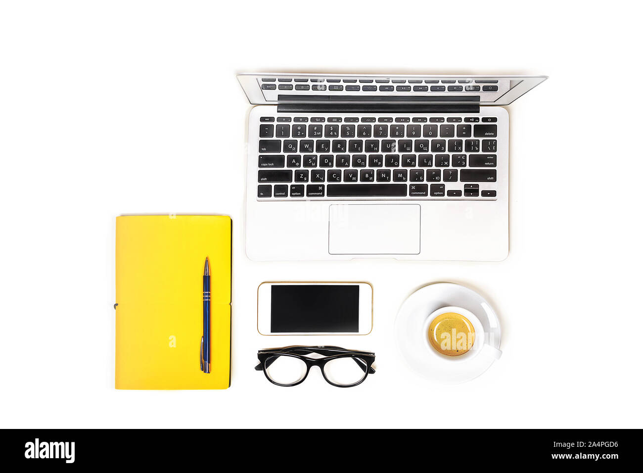 Arbeitsbereich mit Laptop Notebook, Mode Gläser, Tasse Kaffee, Handy und gelbe Notizbuch mit Stift auf weißem Hintergrund, isoliert. Ansicht von oben. Flach. Konzept online einkaufen. Stockfoto