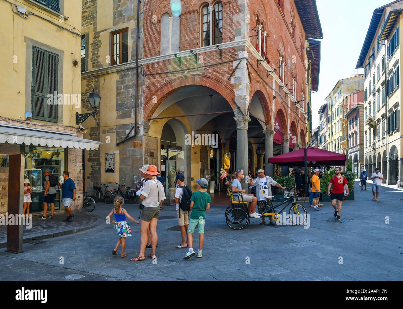 Blick vom historischen Zentrum der berühmten Stadt Pisa mit Touristen auf fahrradrikscha und Café im Freien im Sommer, Toskana, Italien Stockfoto