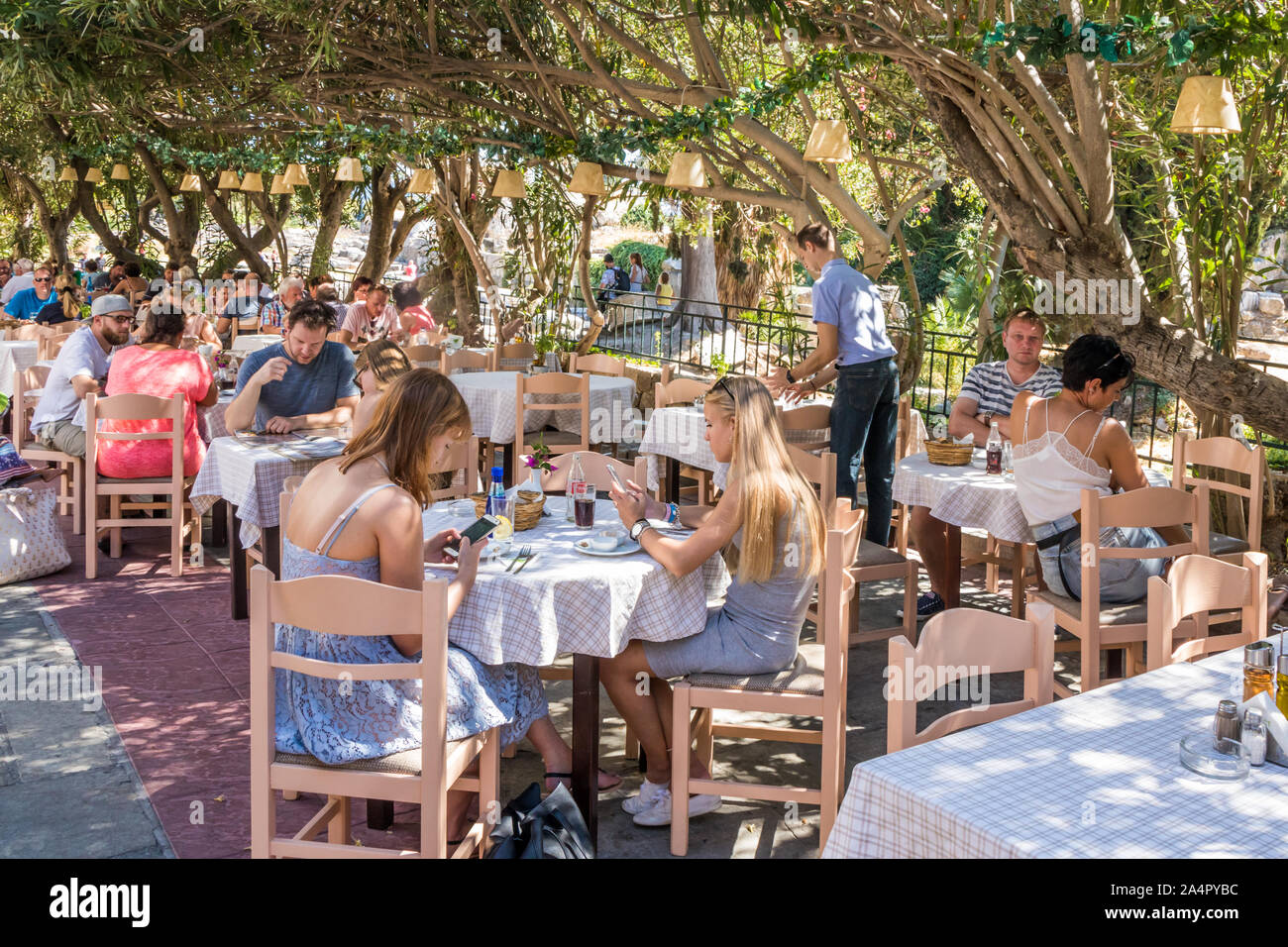 Kos, Griechenland - 18. September 2019: Restaurants shaded unter bougainvillaea. Die Insel ist ein beliebtes Reiseziel Stockfoto