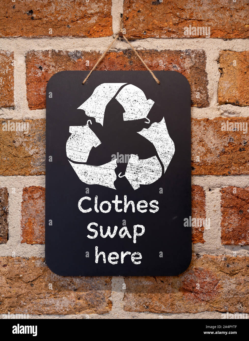 Kleidung tauschen Sie hier Text und Symbol auf der Kreidetafel, nachhaltige Mode und null Abfall, Recycling Bekleidung und Textilien, um Abfall zu reduzieren, Stockfoto