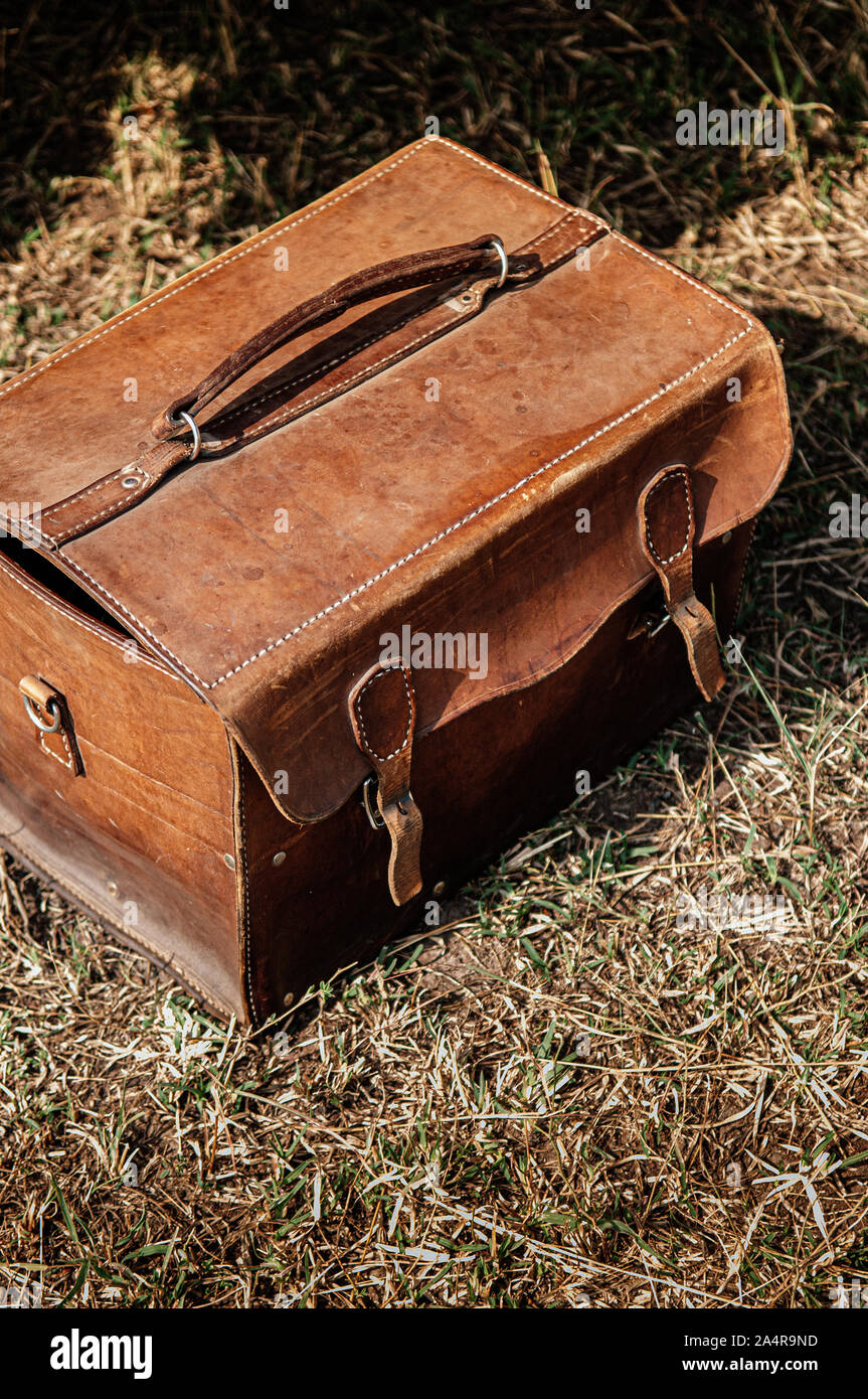 Alten Retro Vintage Leder Picknick Tasche mit matte Oberfläche und Kratzer auf Rasen unter Sonneneinstrahlung bis Details schliessen Stockfoto