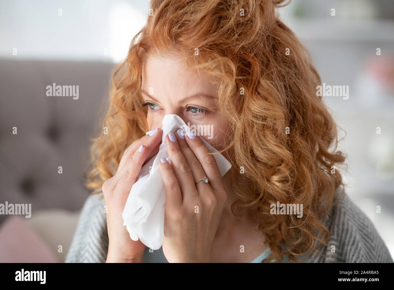 Junge Frau, die den ganzen Tag lang, während mit laufender Nase Stockfoto