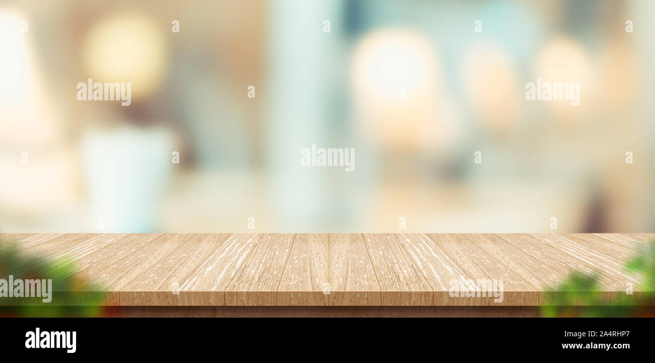 Holz Tisch und verschwommenes Blatt Vordergrund im Restaurant mit bokeh Hintergrund. Produkt anzeigen Vorlage. Business Präsentation Stockfoto