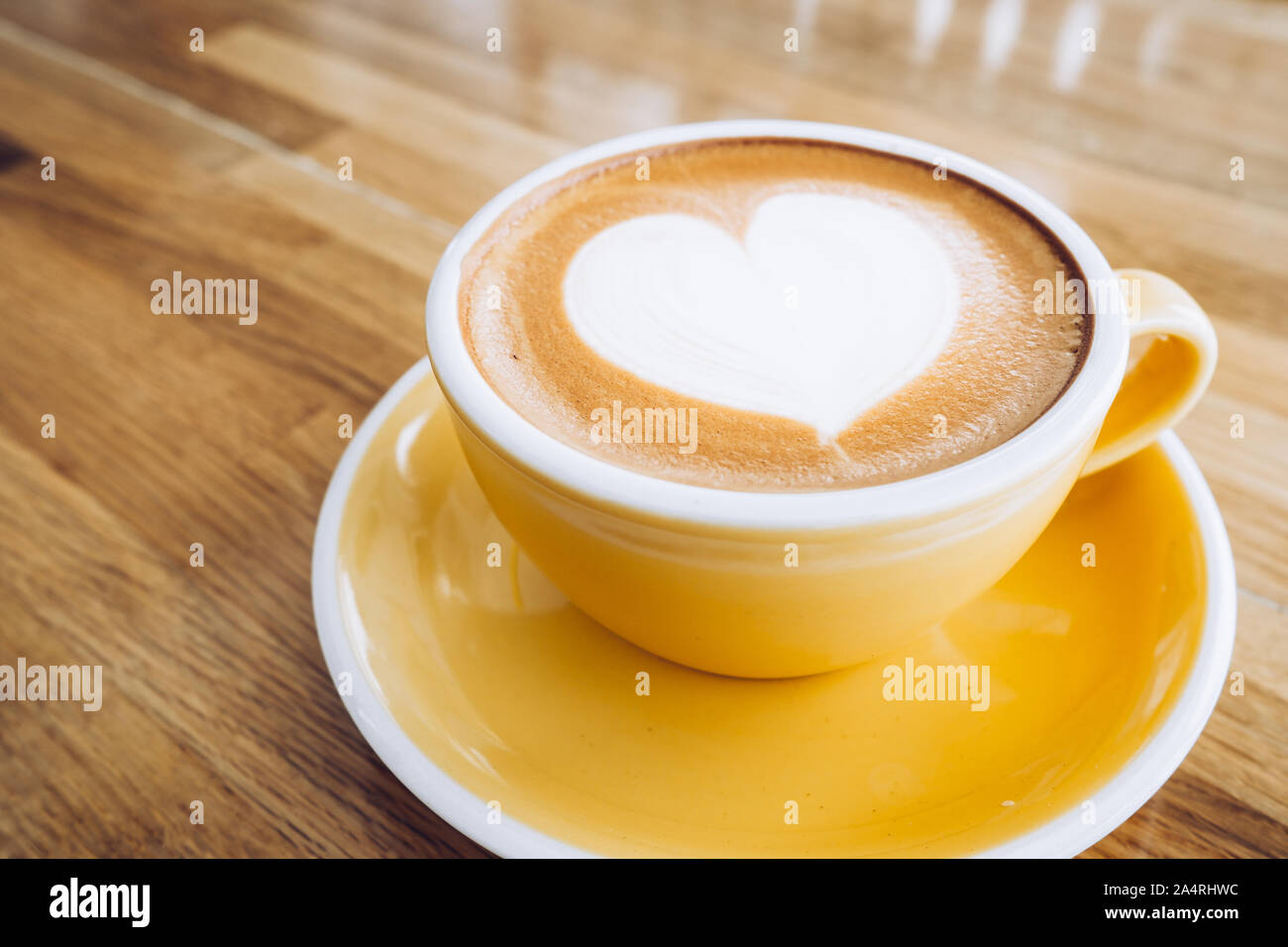 Heißen Cappuccino Tasse auf Holz- Fach mit Herz latte Kunst auf Holz Tisch im Cafe, Banner Größe Essen und Trinken Konzept. Stockfoto
