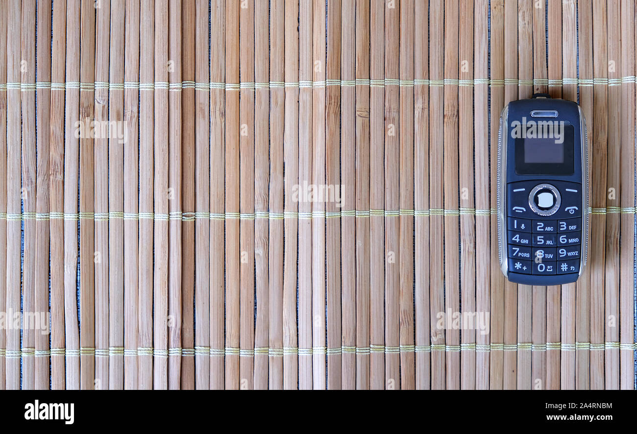 Dark Blue kleines Telefon im Bambus Hintergrund Stockfoto