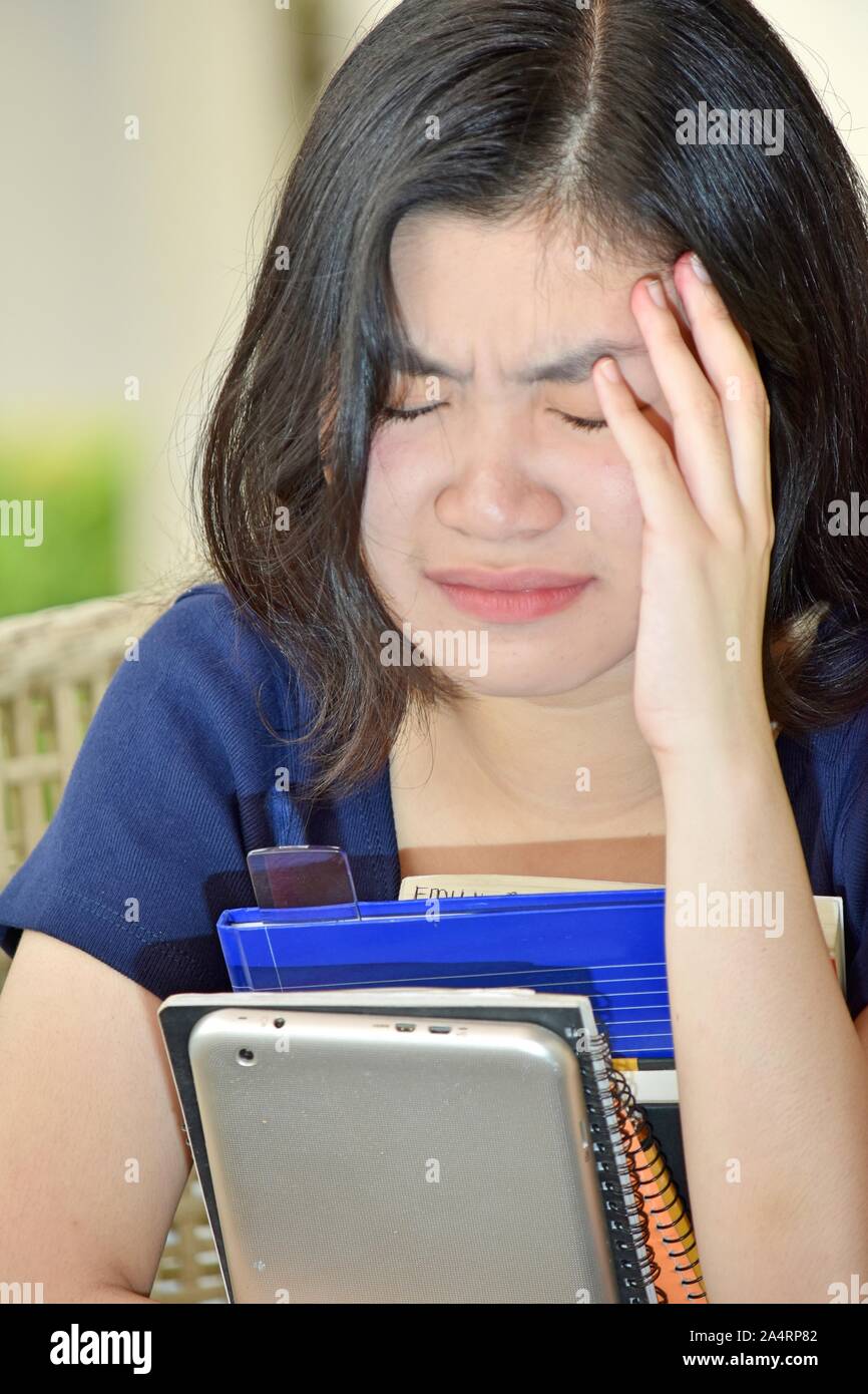 Weinend chinesischer Student Jugendlicher mit Notebooks Stockfoto