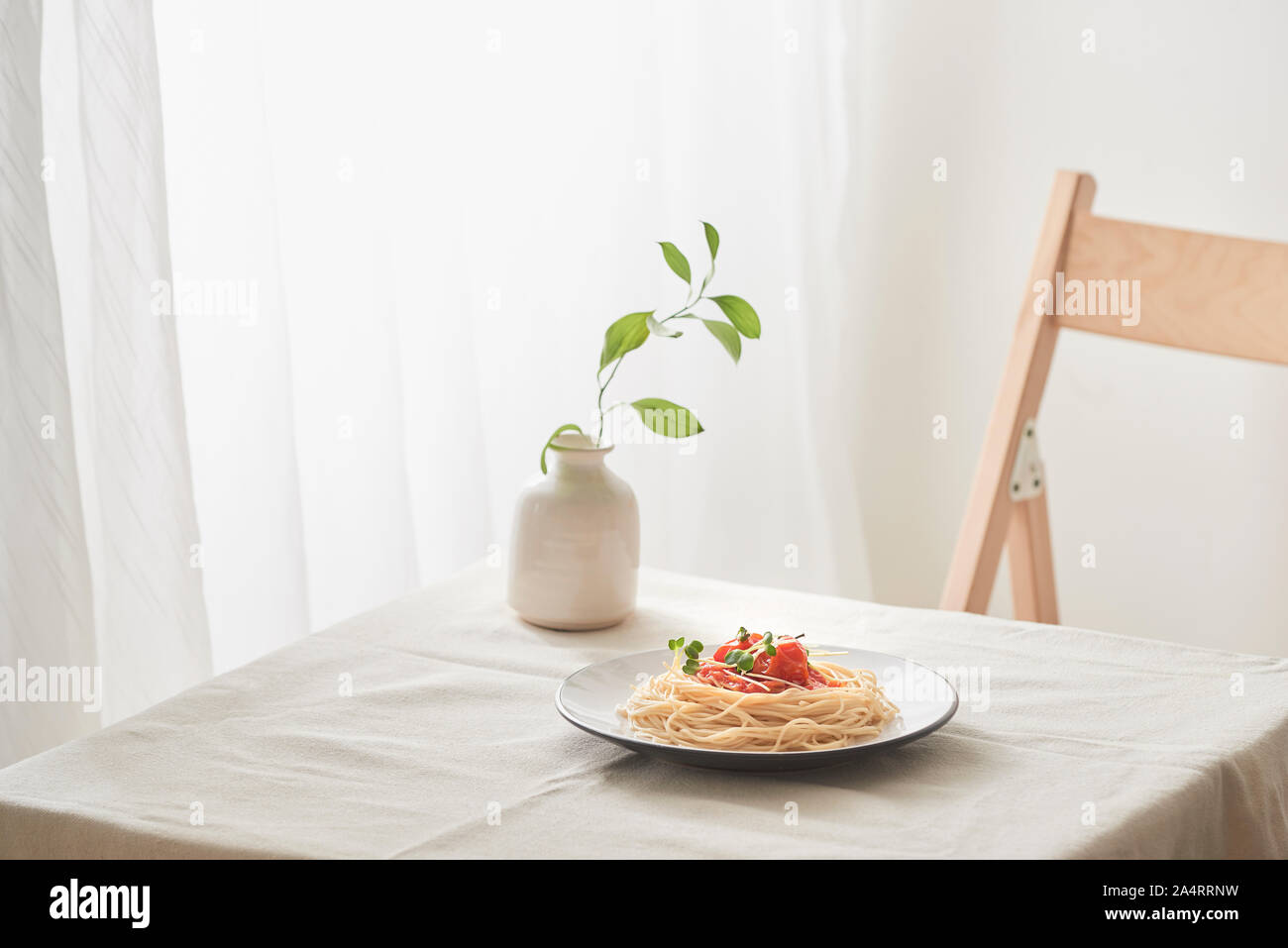 Handgemachte Pasta mit Ragout Soße auf Platte auf Vintage White Tisch mit Sieb und Blumen Stockfoto