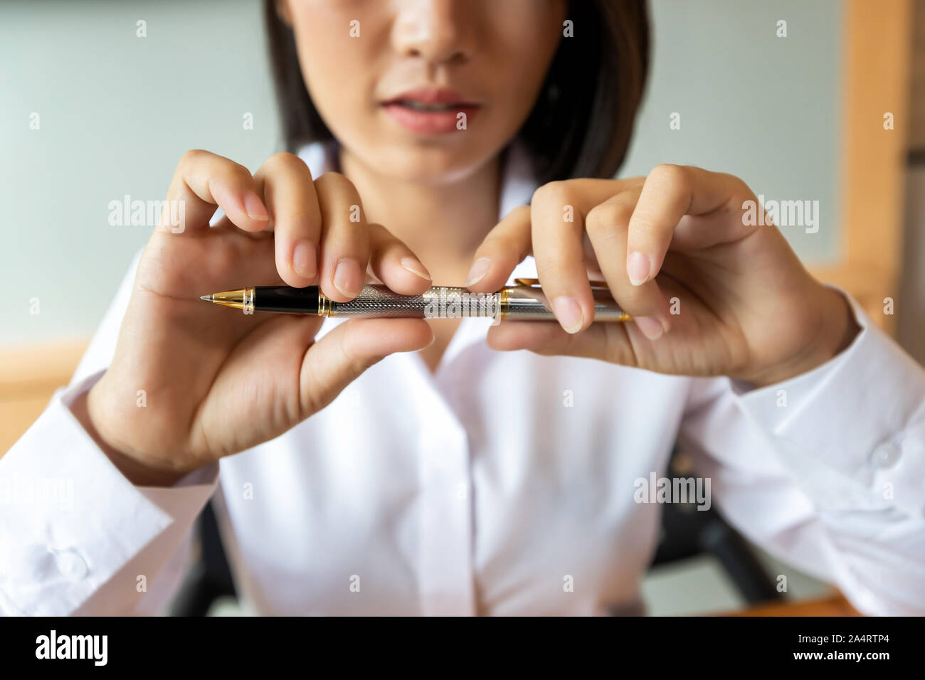 Schöne junge asiatische Frau mit einem Stift in der Hand. Geschäftskonzept. Stockfoto