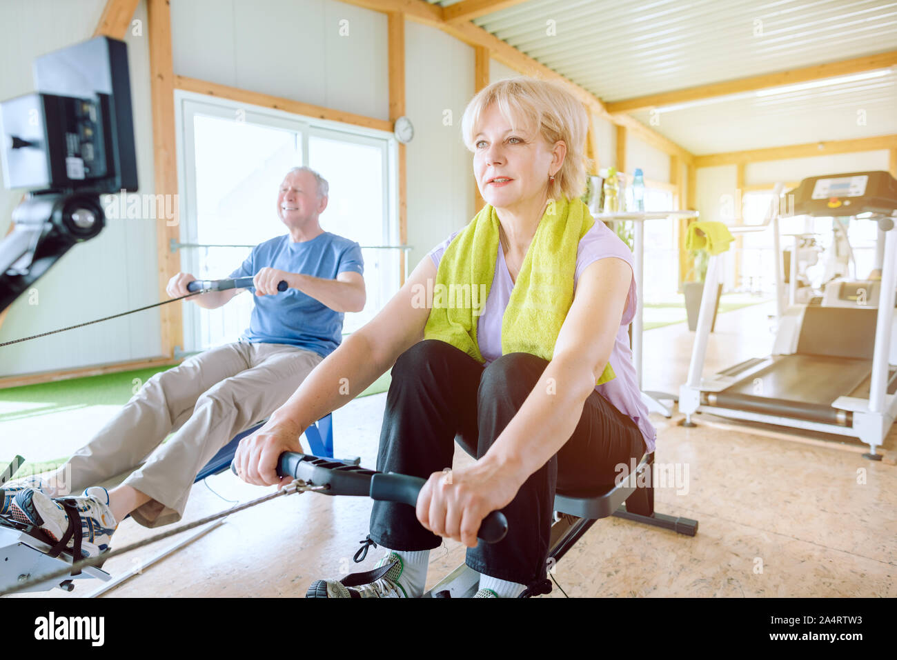 Senior Paar in die Turnhalle auf einem Rudergerät Stockfoto