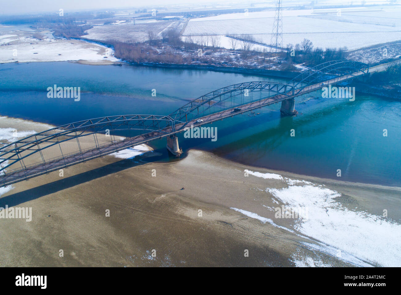 Gerola Brücke im Winter. Alte Brücke, 1913 erbaut, am Po in der Provinz Pavia (Italien). Fluss mit wenig Wasser wegen der Dürre. Stockfoto