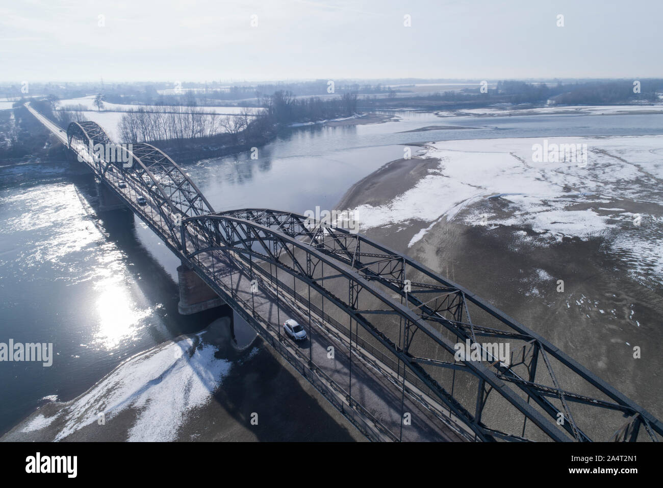 Gerola Brücke im Winter. Alte Brücke, 1913 erbaut, am Po in der Provinz Pavia (Italien). Fluss mit wenig Wasser wegen der Dürre. Stockfoto