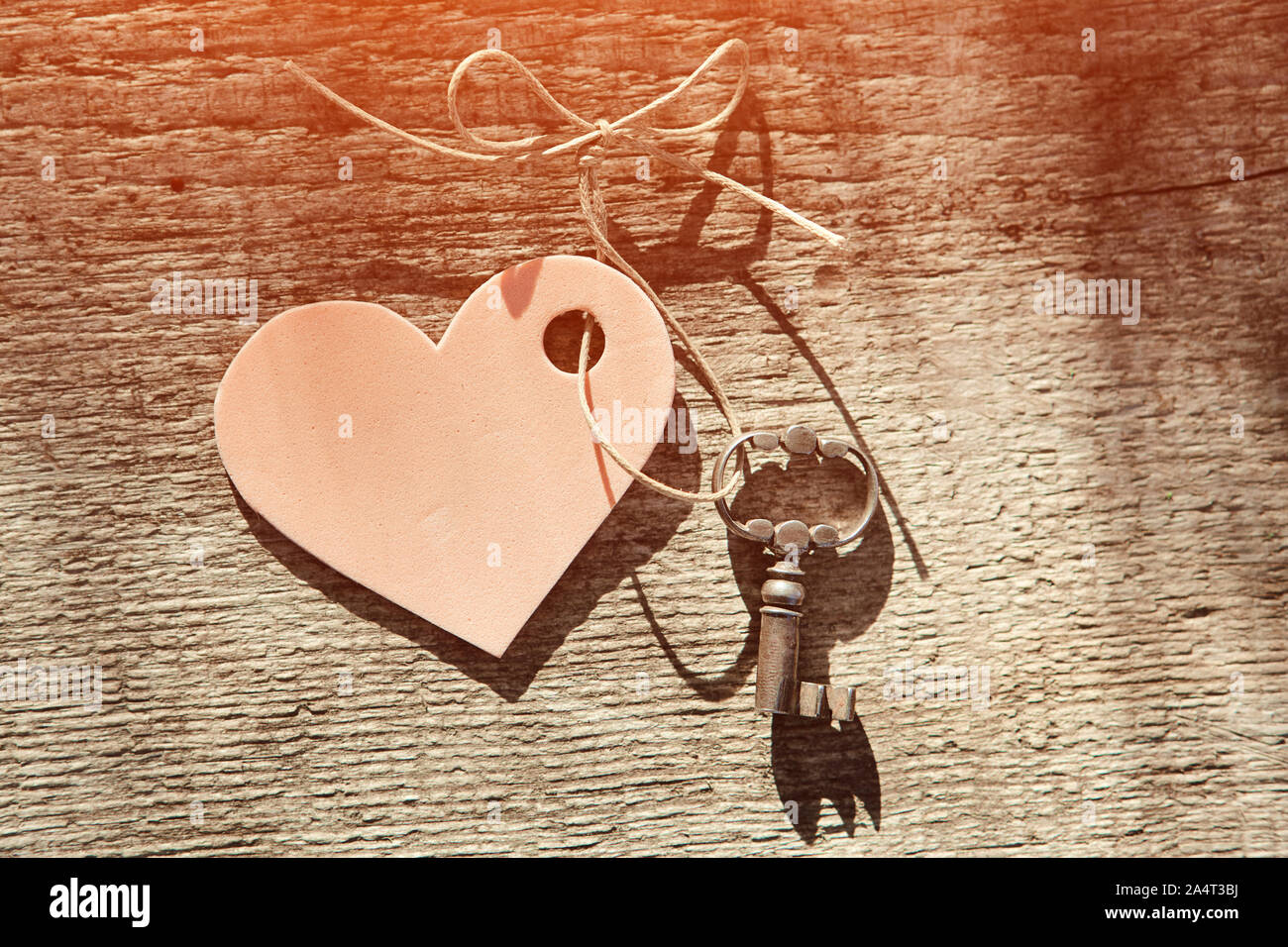 Vintage Schlüssel und rosa Herz auf eine Zeichenfolge mit einem Bogen. Valentine. Platz für Text. Nahaufnahme, Ansicht von oben. Stockfoto