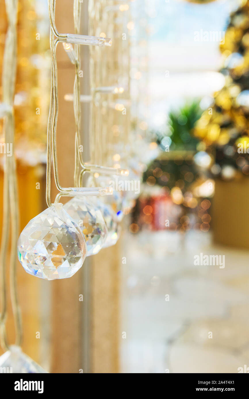 Elegante Weihnachten neues Jahr Dekorationen Kristallkugeln funkelnd in Bokeh leuchtet. Festliche Tanne Baum im Hintergrund Magischer Urlaub Atmosphäre Stockfoto