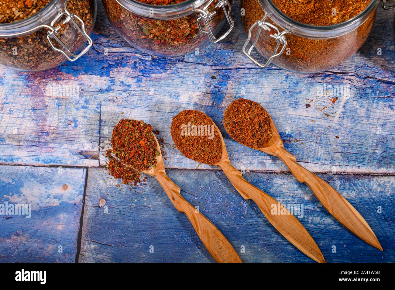 Duftende Gewürze in hölzerne Löffel und Gläser auf dem Tisch Stockfoto