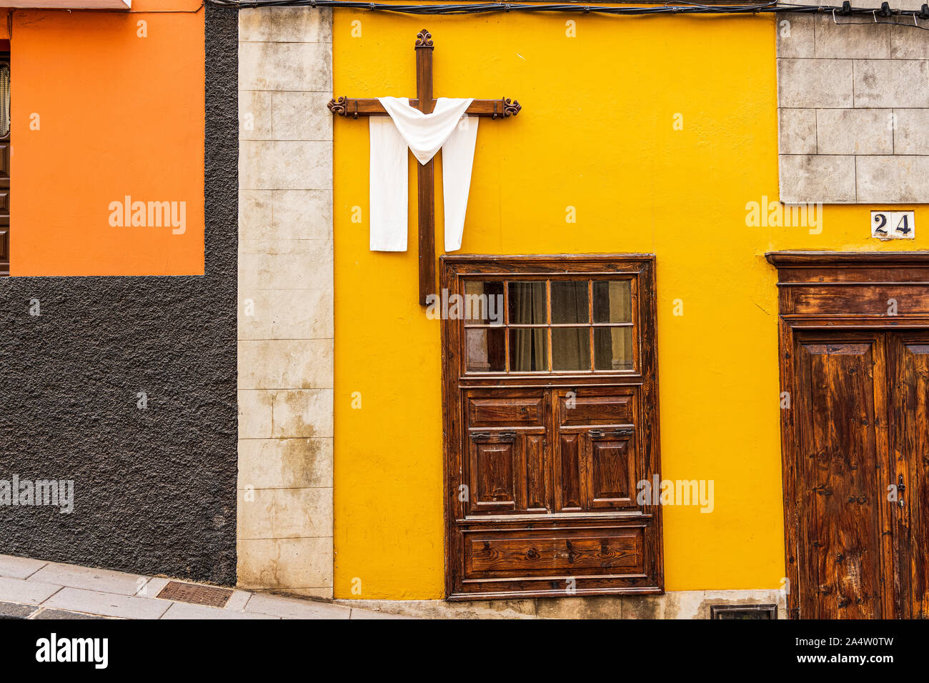 Kreuz drapiert, mit einem weißen Tuch auf einem gelben Außenwand eines Hauses in der Calle San Juan in La Orotava als Teil einer religiösen Fiesta, Teneriffa, Canar Stockfoto