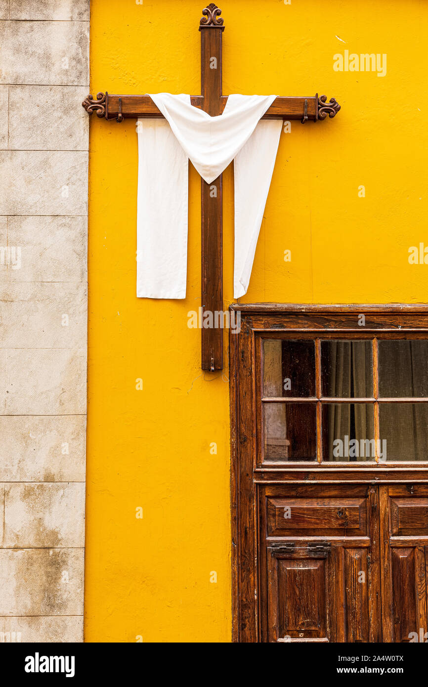 Kreuz drapiert, mit einem weißen Tuch auf einem gelben Außenwand eines Hauses in der Calle San Juan in La Orotava als Teil einer religiösen Fiesta, Teneriffa, Canar Stockfoto
