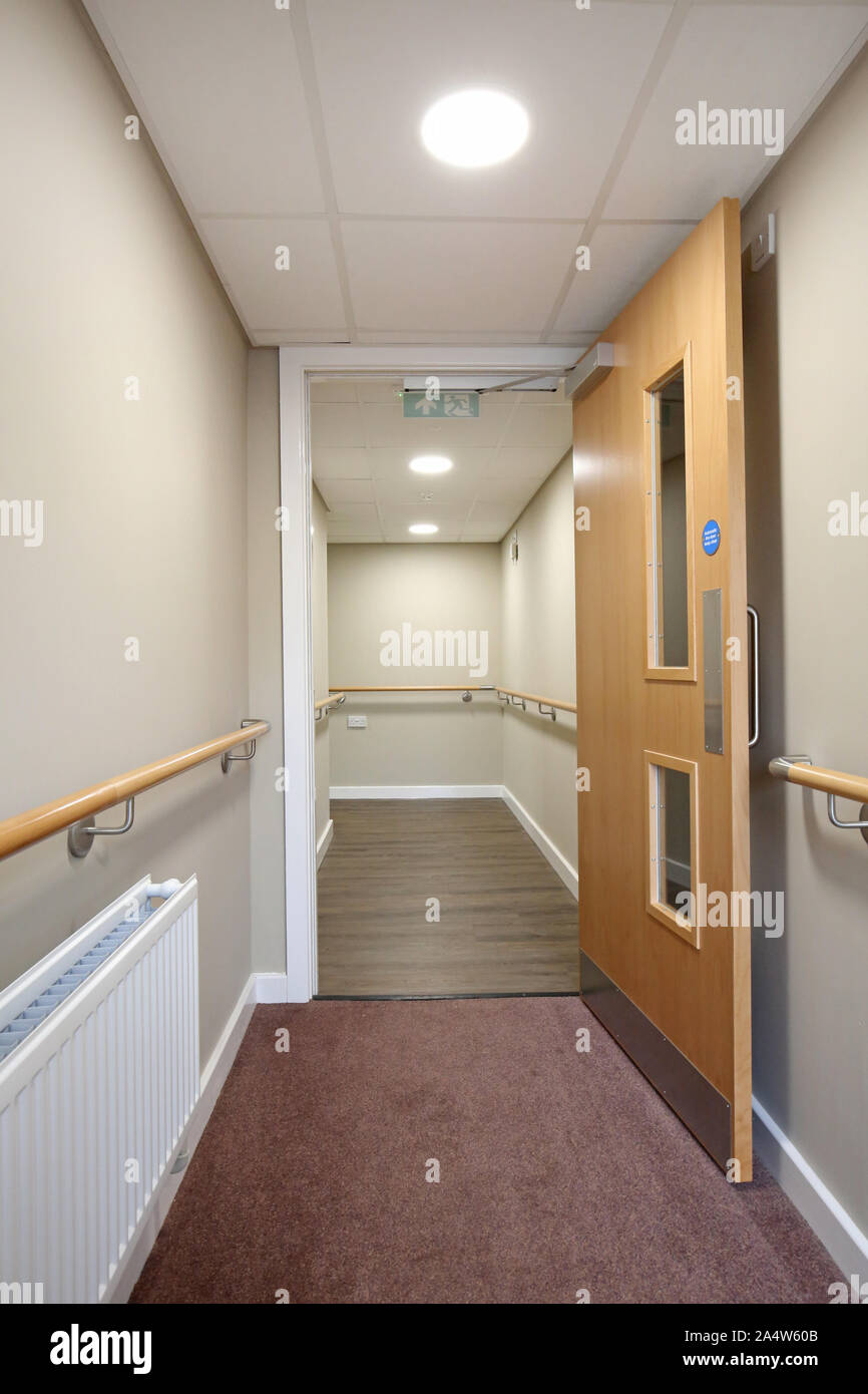 Korridor in einem neu renovierten Care Home in der Nähe von Wakefield, Großbritannien. Zeigt Sicherheit Handläufe und Brandschutztür. Stockfoto