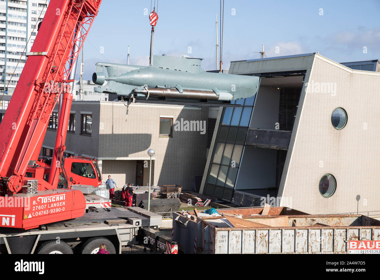 16. Oktober 2019, Bremen, Bremerhaven: Ein kleines U-Boot vom Typ 'Seehund' aus dem Zweiten Weltkrieg ist mit schweren Kränen aus dem Deutschen Schiffahrtsmuseum aufgehoben. Nach einer umfangreichen Rekonstruktion, Museum die Ausstellung wird ein Platz im Erdgeschoss finden. Um die 12 Meter lange und 12 Tonnen schwere U-Boot Es zu transportieren, eine grosse Fensterfront wurde entfernt. Foto: Jörg Sarbach/dpa Stockfoto