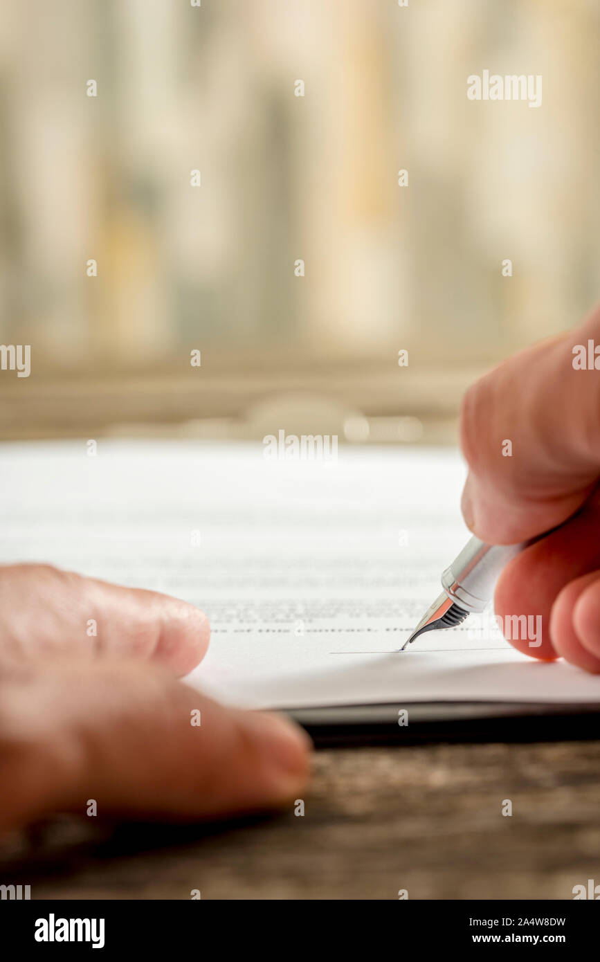 Extreme Low Angle View auf qualitativ hochwertige Füllfederhalter in der Hand schreiben persönliche Unterschrift auf Papier. Stockfoto