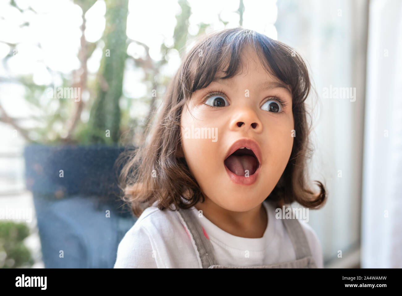 Süße kleine Mädchen, während zu Hause spielt, überrascht Stockfoto