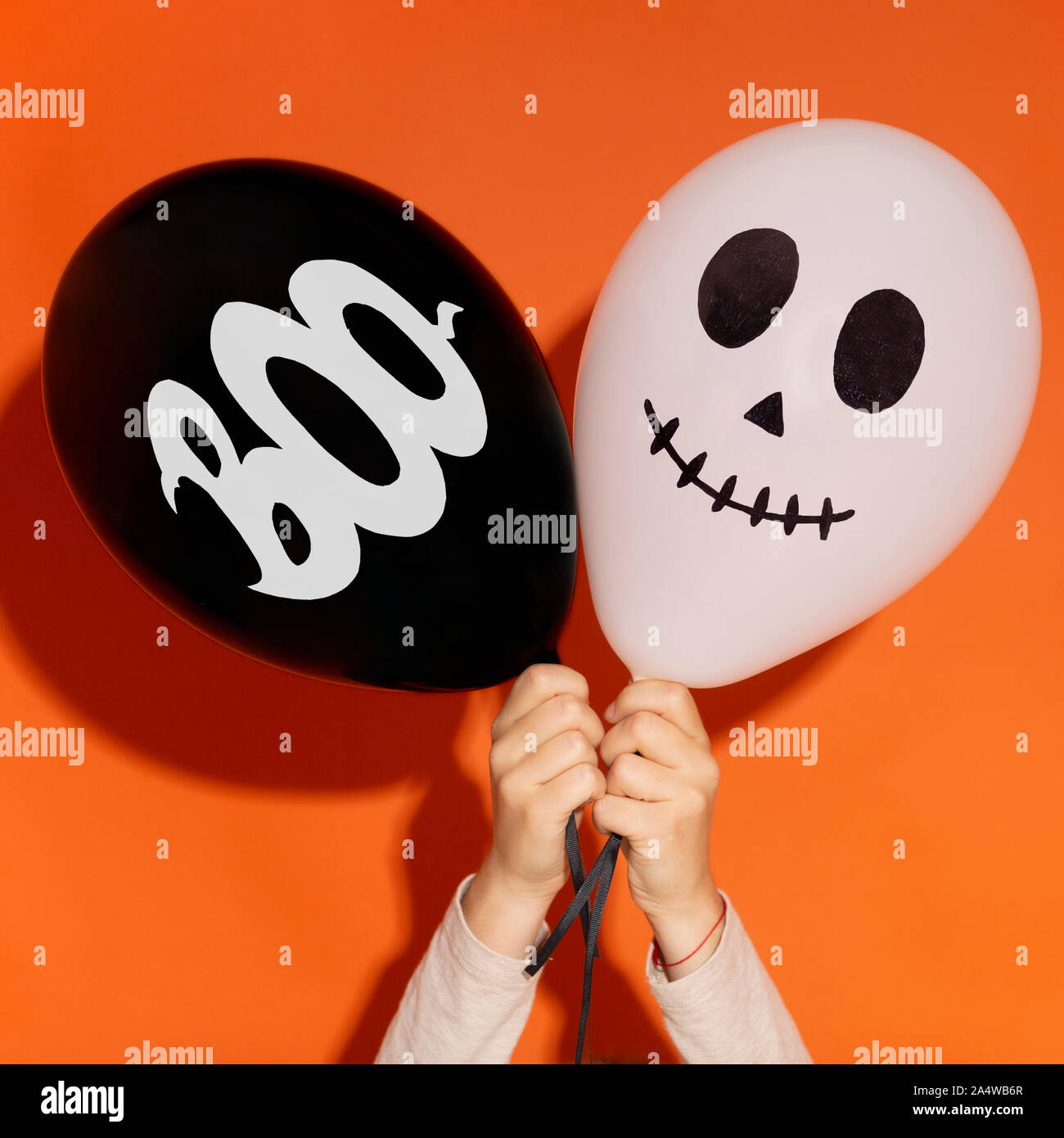 Kreative Halloween Ballons mit Gesicht und Text in Frau Hände Stockfoto