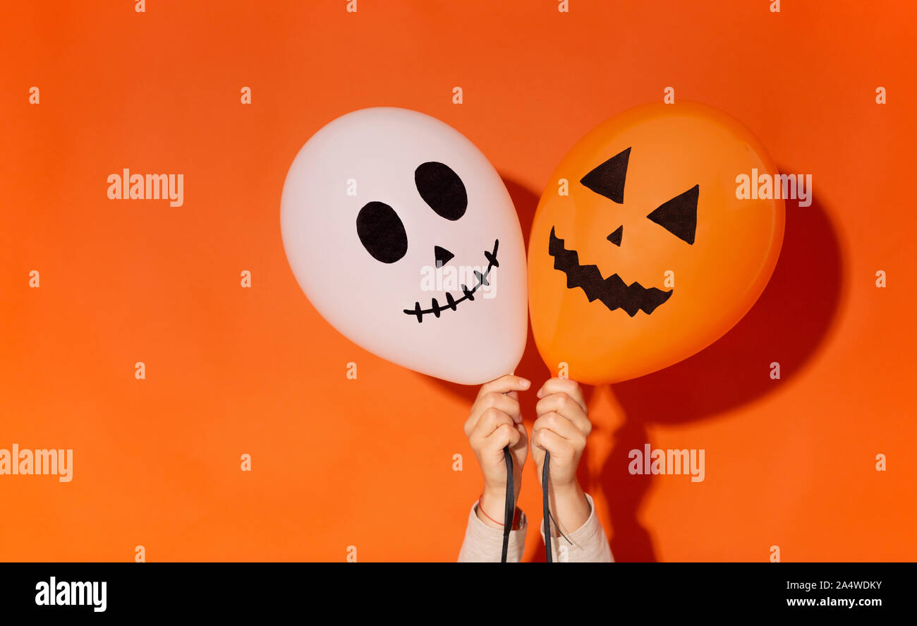 Farbe Ballons mit Halloween gruselige Gesichter in Frau Hände Stockfoto