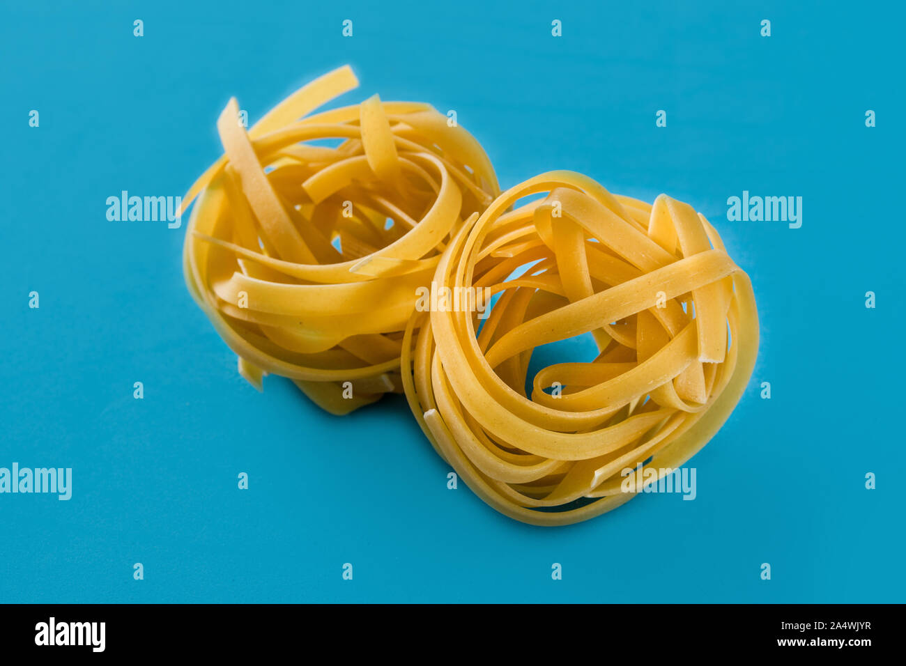 Capellini Pasta auf blauem Hintergrund Stockfoto