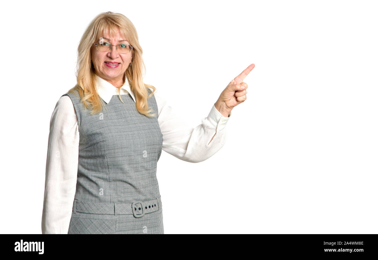 Reife Frau zeigt mit dem Finger auf der rechten Seite auf weißem Hintergrund. Ältere Frau, die auf leeren Raum für Text. Lehrer. Stockfoto