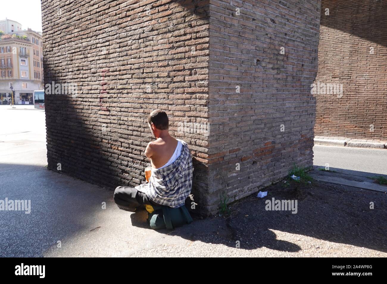 Ein bewaffneter Mann sitzt bei Porta Asinaria Betteln in Rom, Italien Stockfoto