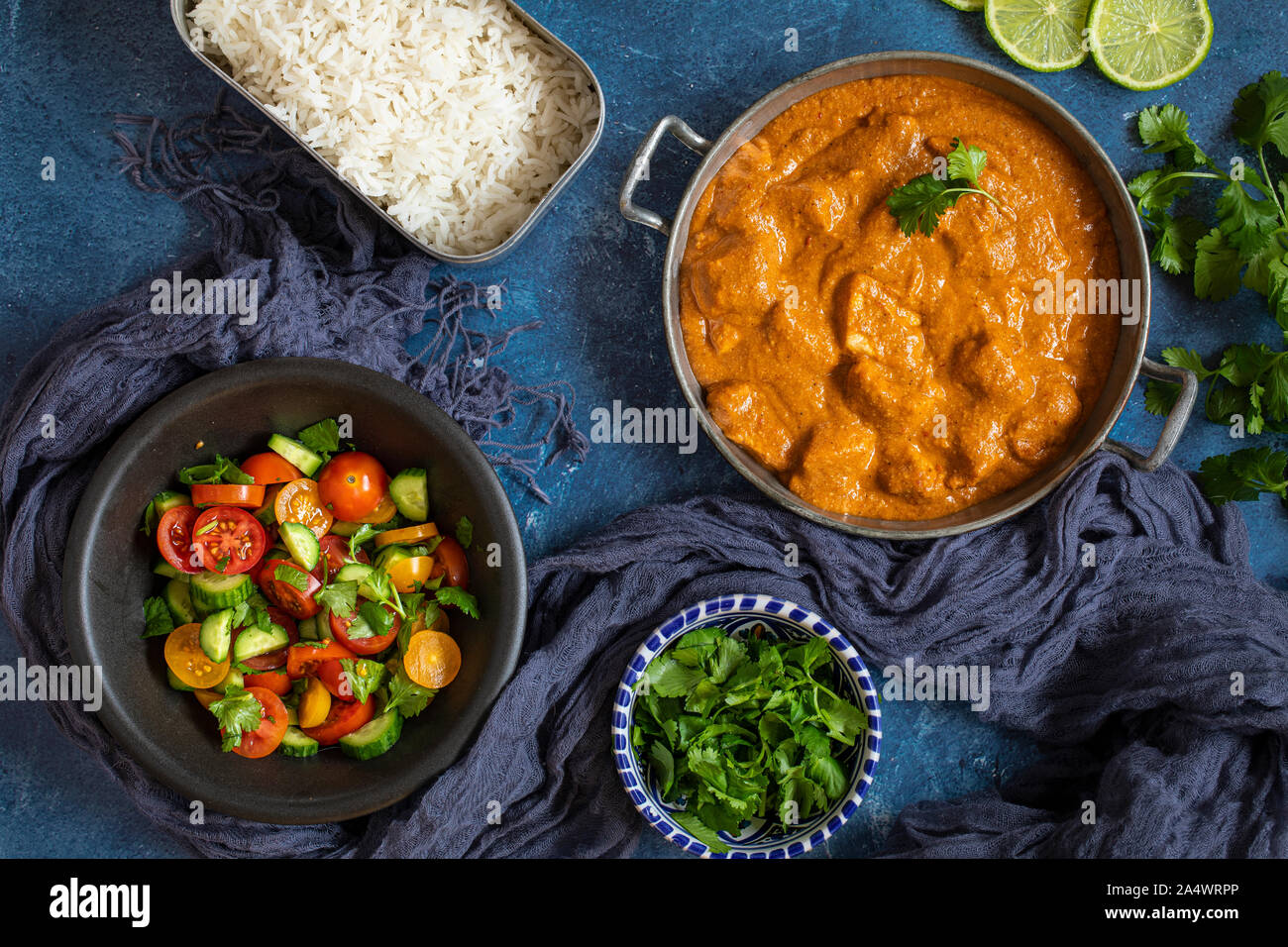 Eine bunte indische Curry Abendessen mit frischen Salat flach von oben gesehen. Mit Kalk, Tomaten, Gurken, Koriander und Reis. Stockfoto