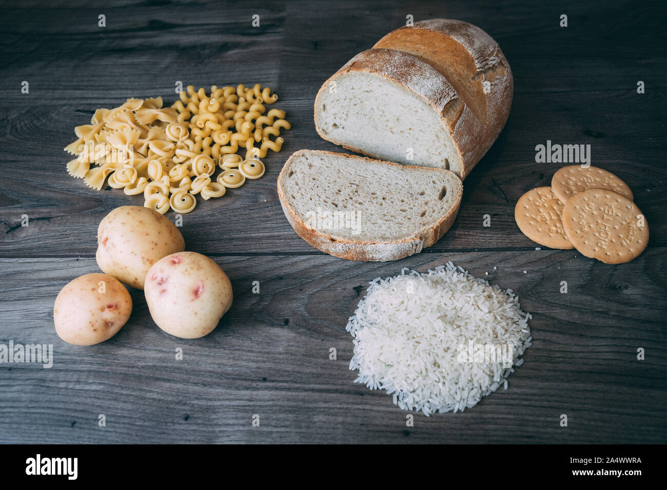 Gemeinsame schlechte Kohlenhydrate zu vermeiden wie weißes Brot, Teigwaren, Reis, Kartoffeln und buscuits Festlegung auf einen hölzernen Tisch von oben gesehen Stockfoto