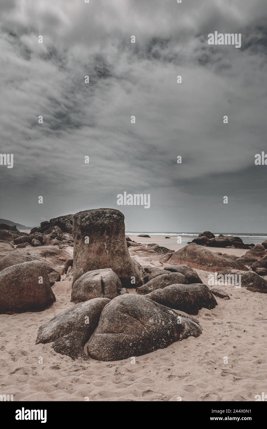 In der Nähe von Felsen am Strand ein Tag mit stürmischen Wolken im Hintergrund. Steine, Sand und Wasser. Stockfoto In der Nähe von Felsen am Strand ein Tag mit stürmischen Wolken im Hintergrund. Steine, Sand und Wasser. Stockfoto