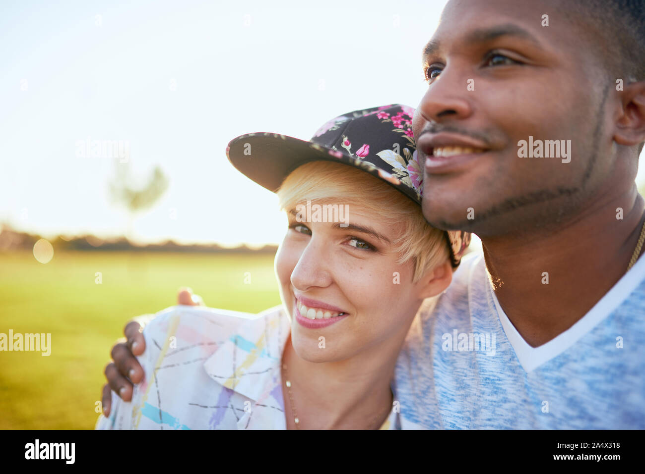 Mixed Race Paar millennials in einem Gras Feld kuscheln und s Stockfoto