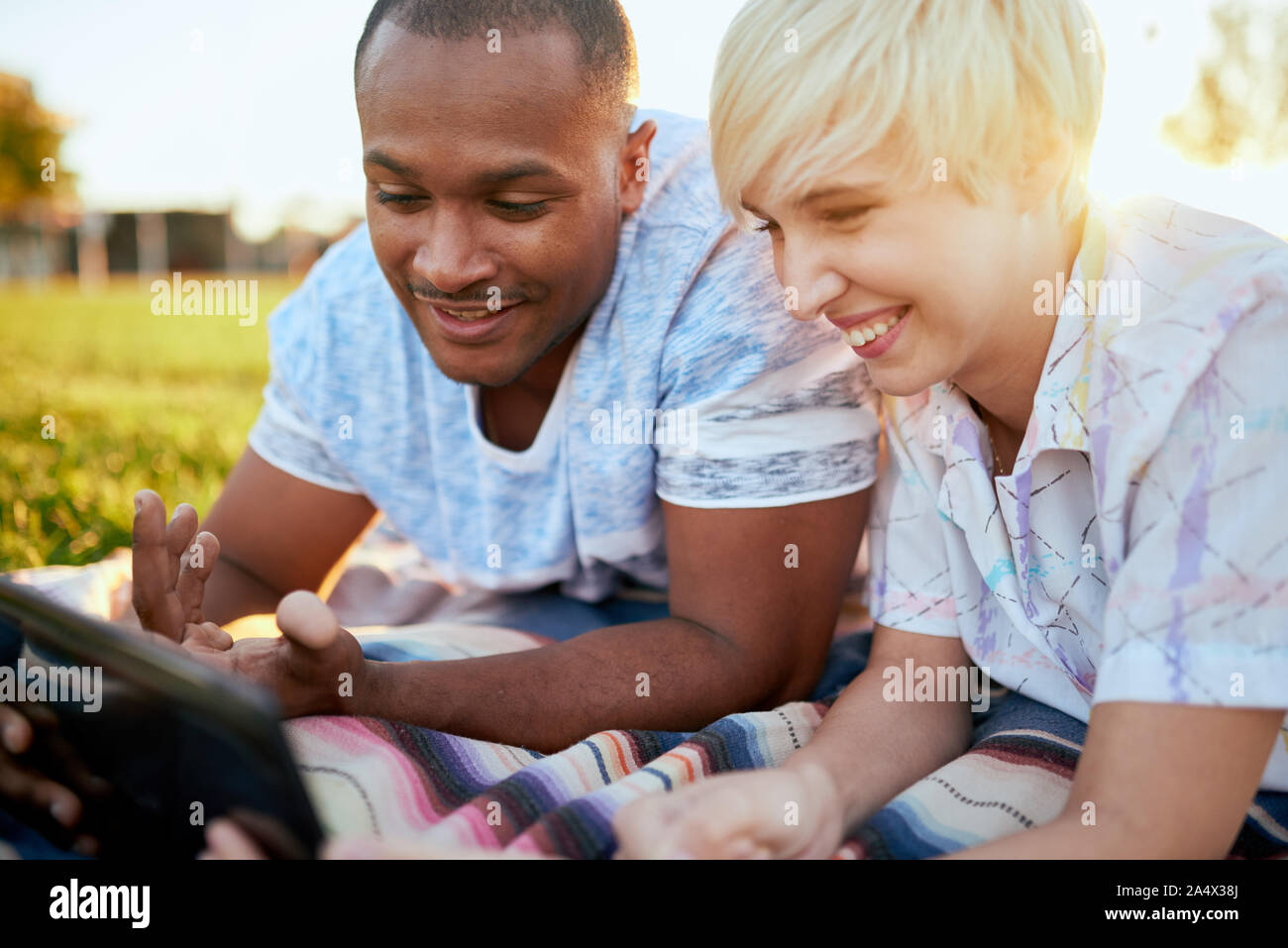 Mixed Race Paar tausendjährigen in eine Rasenfläche mit Blick auf eine di Stockfoto