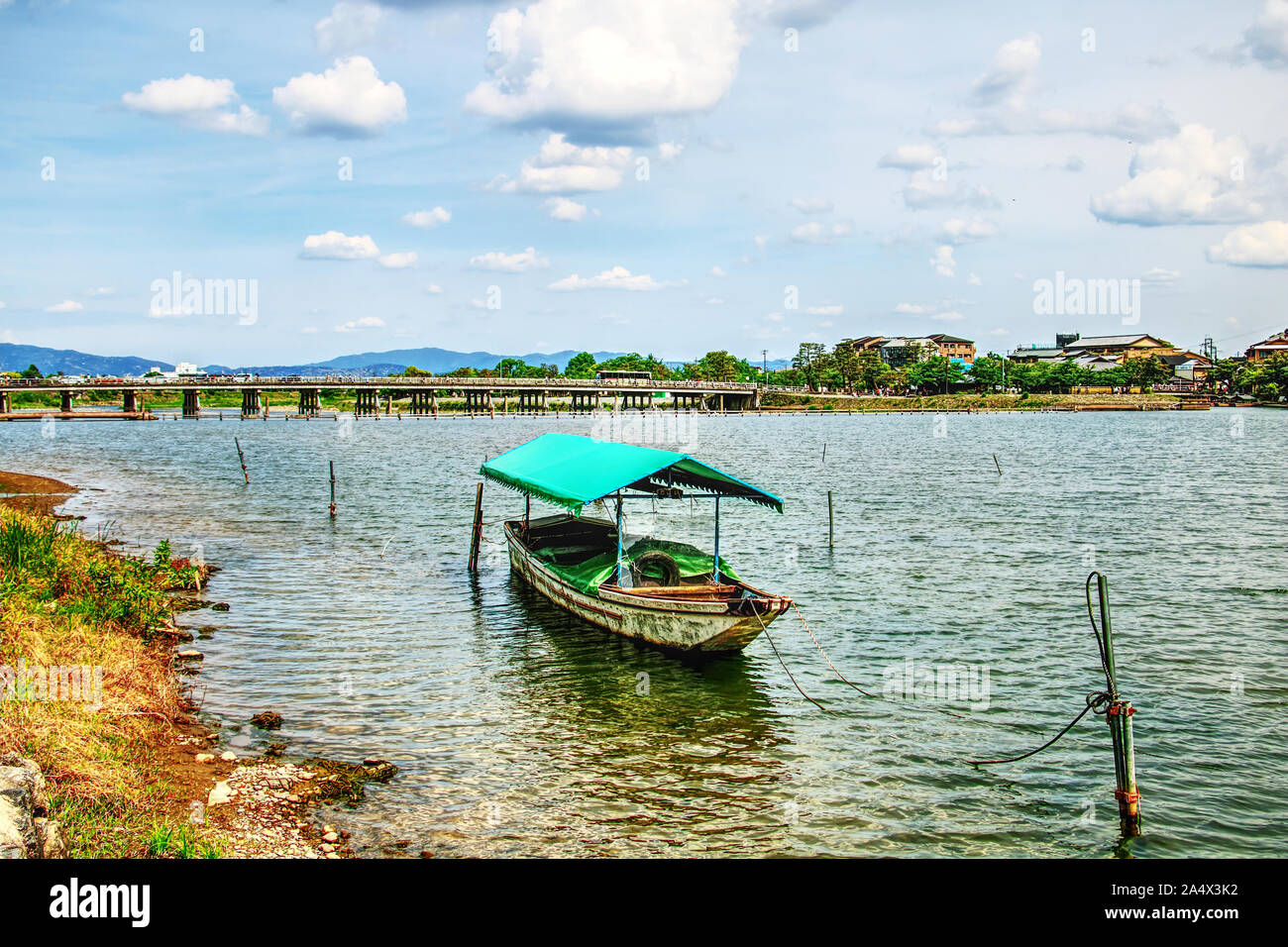 Ein Boot vertäut auf Oi-gawa Fluss vor Togetsu-kyo Bridge, Arashiyama, Kyoto, Japan Stockfoto