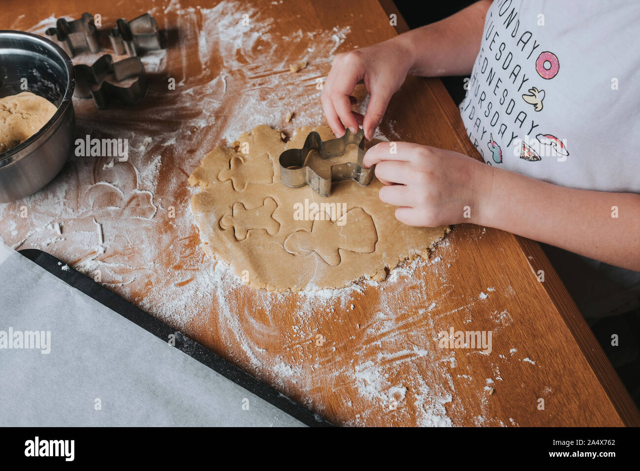 Junge Mädchen schneiden unsere Gingerbread Man aus Teig Stockfoto