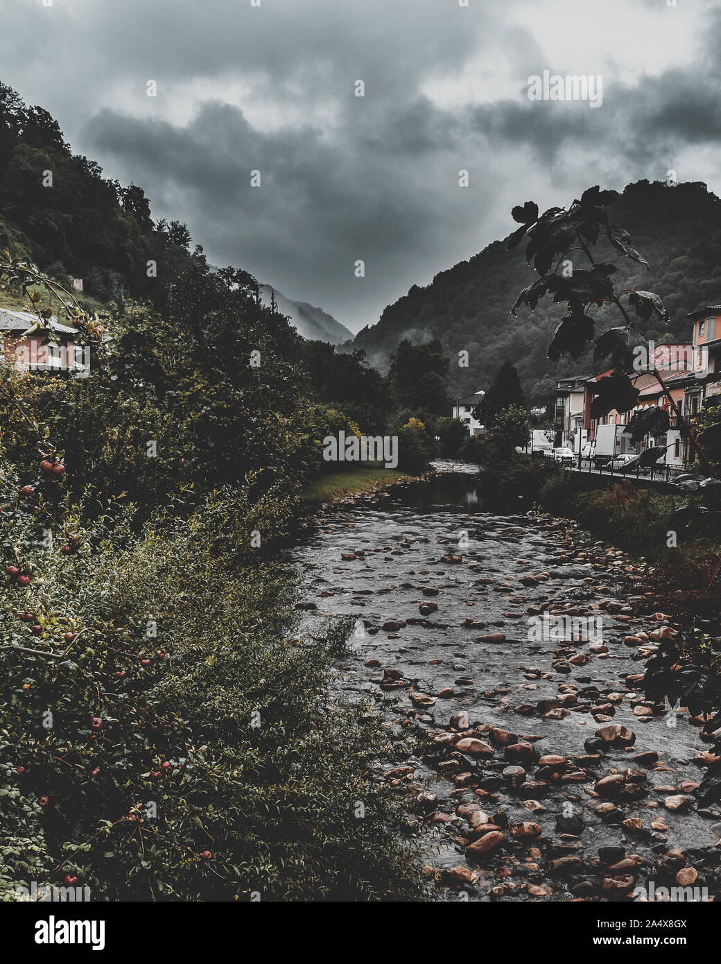 Stony River fast ohne Wasser zwischen den Bergen von einer Brücke mit stürmischem Wetter. Belmonte de Miranda in Asturien. Stockfoto Stony River fast ohne Wasser zwischen den Bergen von einer Brücke mit stürmischem Wetter. Belmonte de Miranda in Asturien. Stockfoto