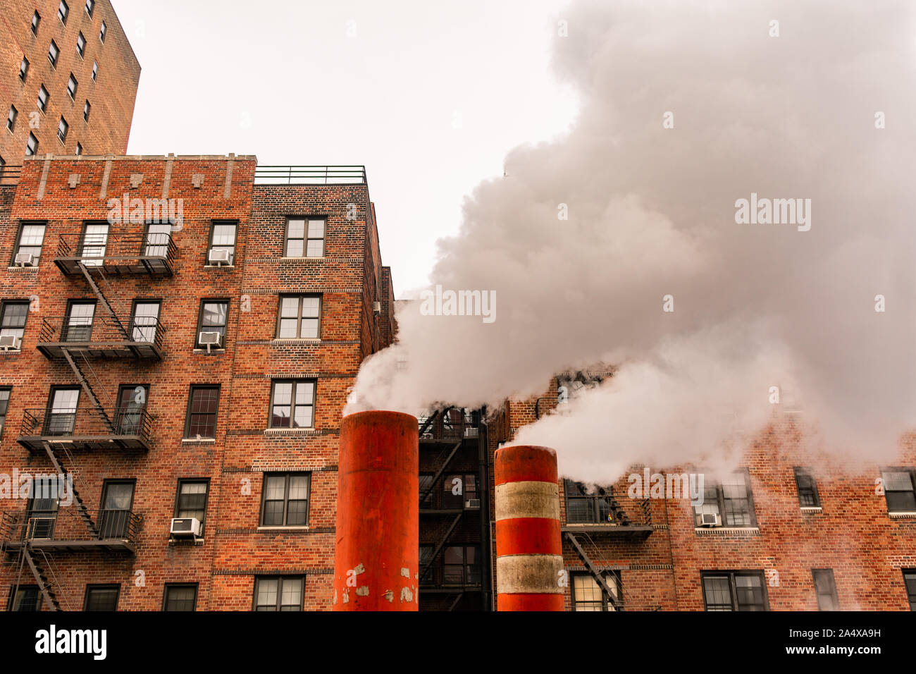 Orangefarbene Dampfrohre mit Dampf in New York City Stockfoto