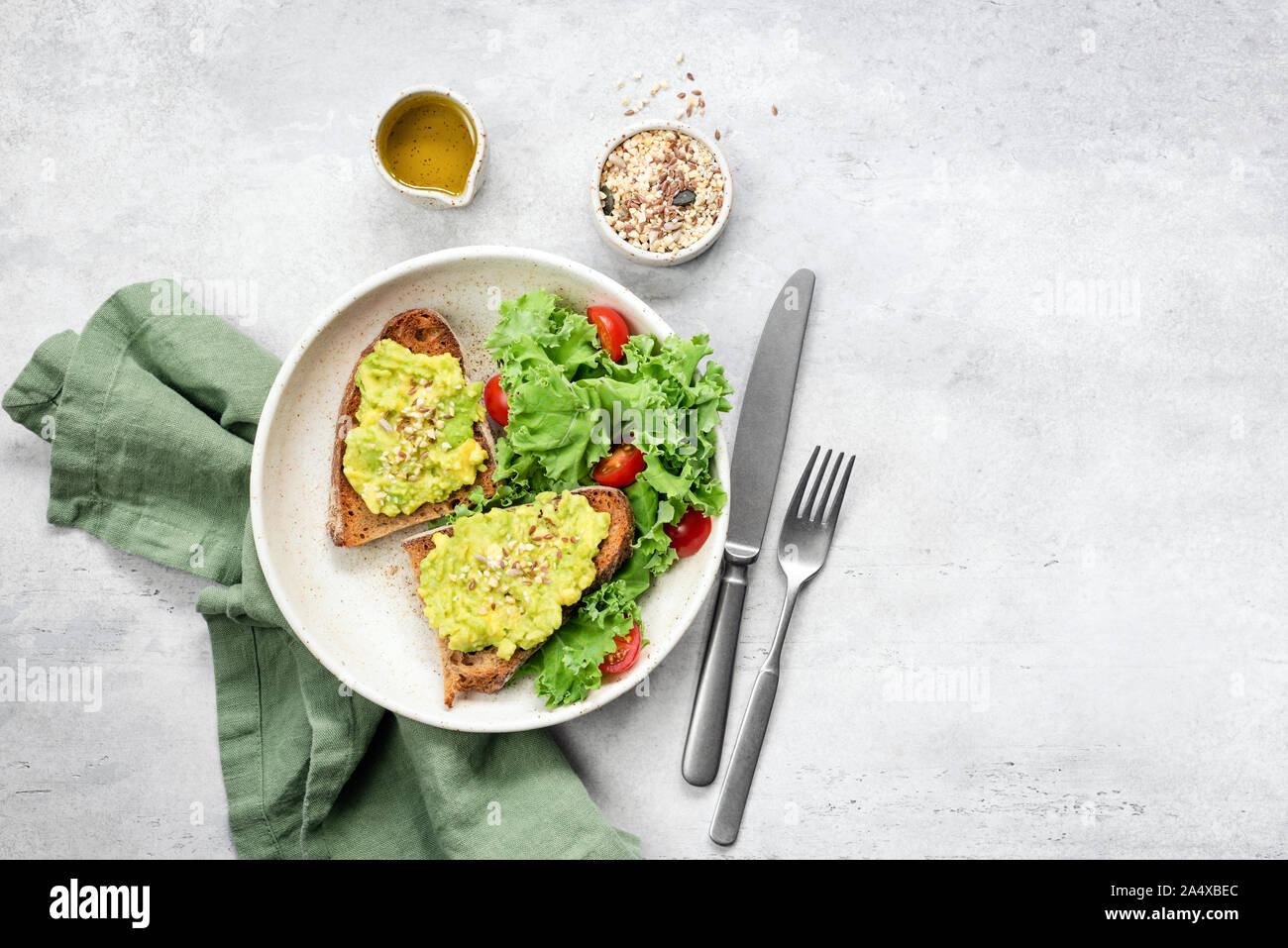 Avocado Toast und kale Tomaten Salat auf Teller. Gesunde, ausgewogene vegane vegetarische Mahlzeit. Ansicht von oben, kopieren Raum Stockfoto