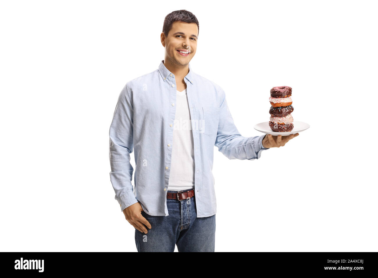 Junge Mann hält einen Teller mit Donuts und lächelnd auf weißem Hintergrund Stockfoto