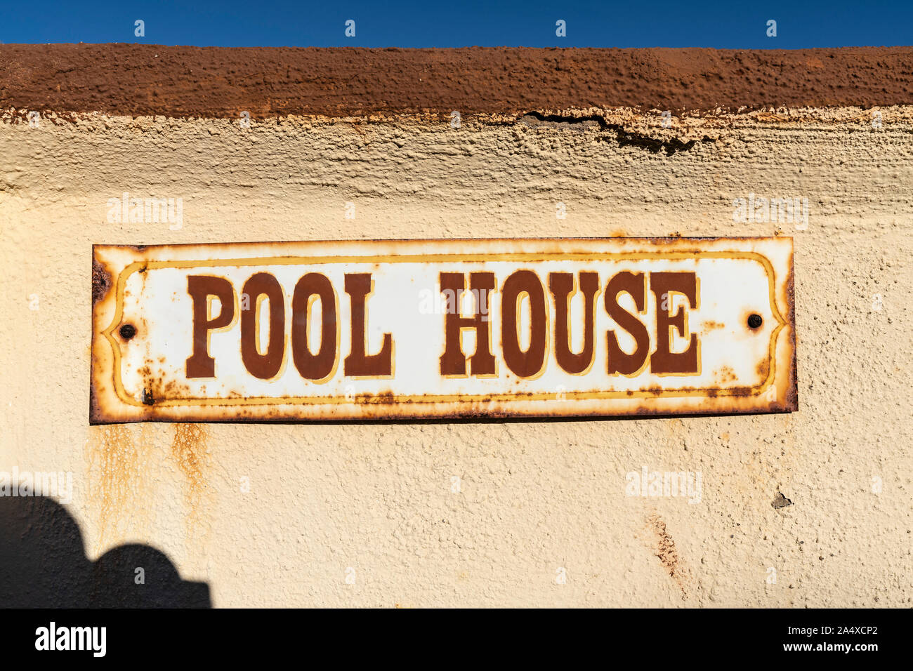 Alten rostigen Pool Haus Zeichen auf Stuck Wand. Stockfoto