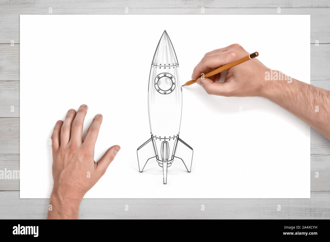 Männliche Hände mit einem Bleistift eine Weltraumrakete mit einem runden Strahler zu zeichnen. Stockfoto