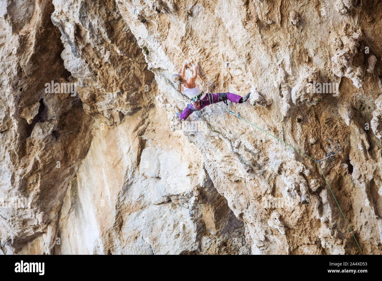 Kaukasische junge Frau klettern anspruchsvolle Strecke auf überhängenden Klippe Stockfoto