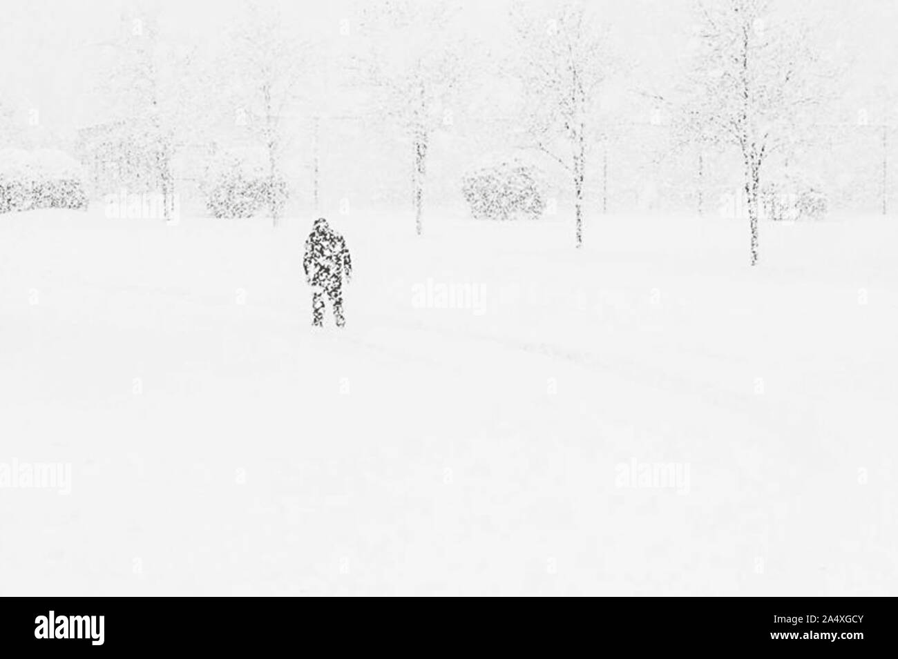 Ein Mann Ventures in ein blendendes Blizzard auf einem Schnee Tag von der Arbeit nach Hause. Stockfoto