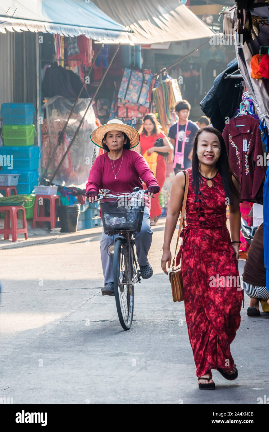 Mae Sot, Thailand - 3. Februar 2019: Frauen auf dem Fahrrad und zu Fuß auf der Straße. Es gibt keine ethnischen Gruppen in der Stadt. Stockfoto