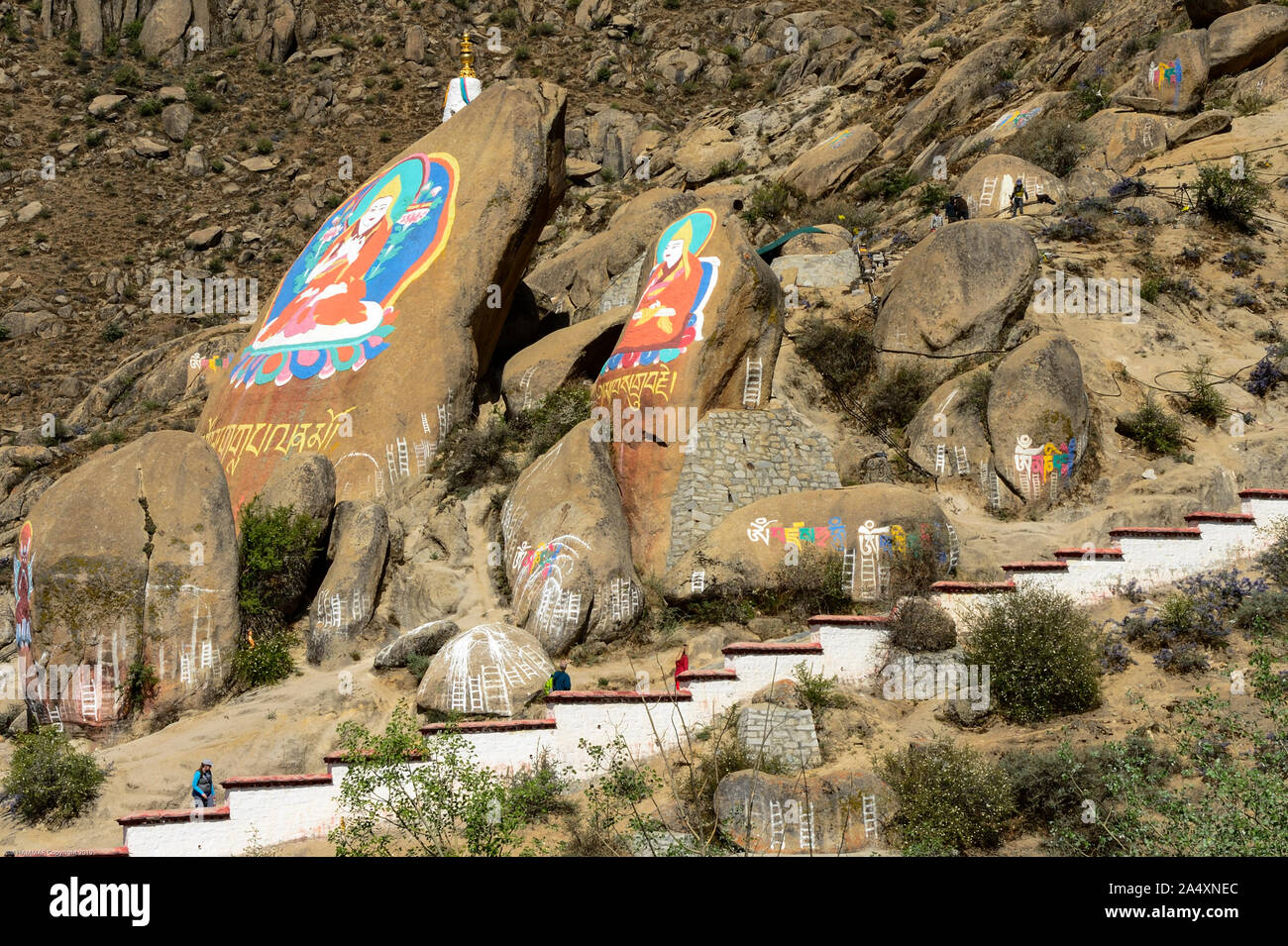 Gemalte Bilder von religiösen Persönlichkeiten Felsen entlang einer Treppe an Deprung Kloster in Lhasa, Tibet schmücken. Stockfoto