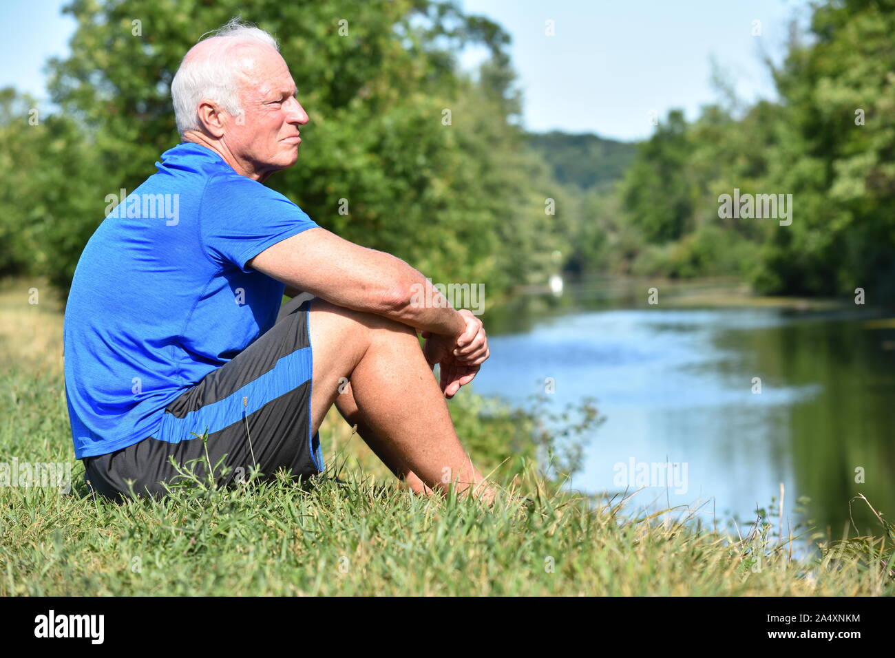 Erwachsene männliche Ruhend Sitzen am Fluss Stockfoto