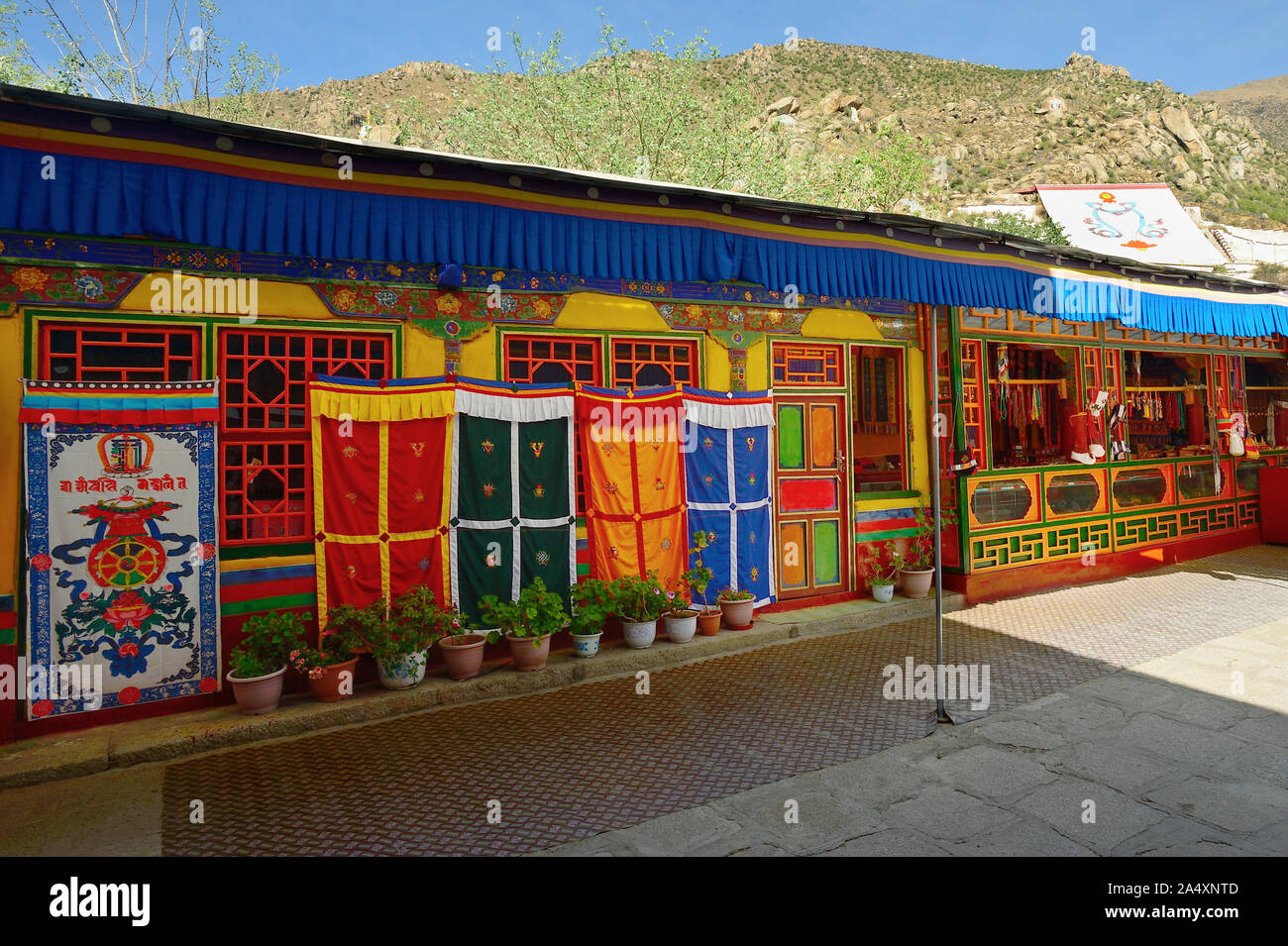 Ein Geschenk Store zeigt religiöse Symbole und waren zusammen einen Gehweg an der Deprung Kloster in Lhasa, Tibet. Stockfoto